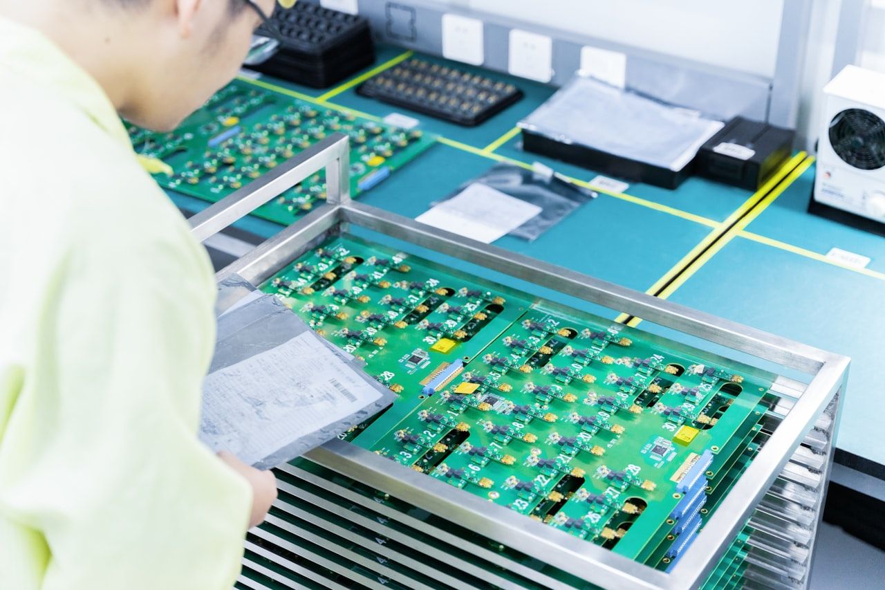 Technician handling populated circuit boards in an electronics assembly factory